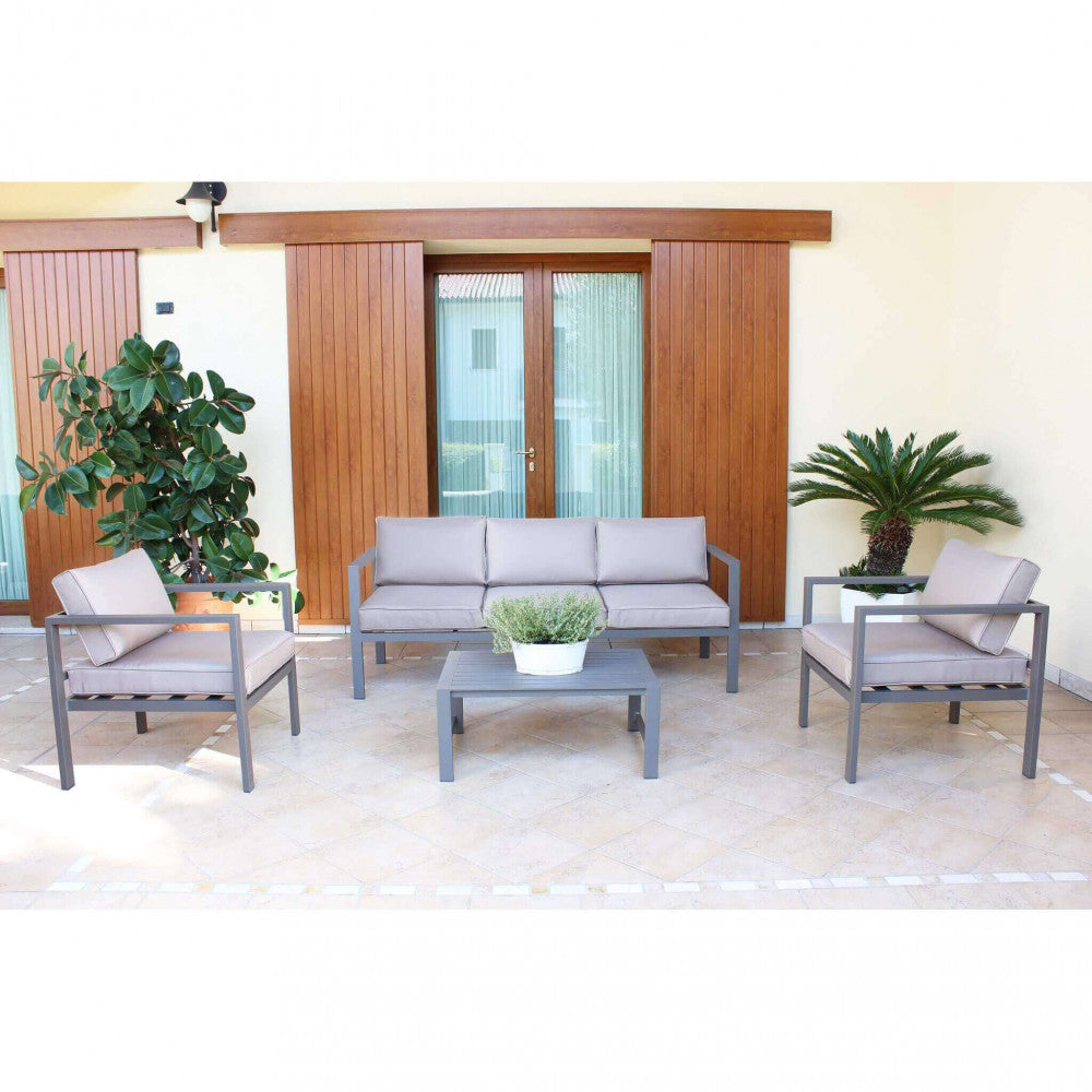 Salotto Avana posizionato su un patio piastrellato di fronte a grandi porte finestre in legno, arricchito da piante ornamentali.