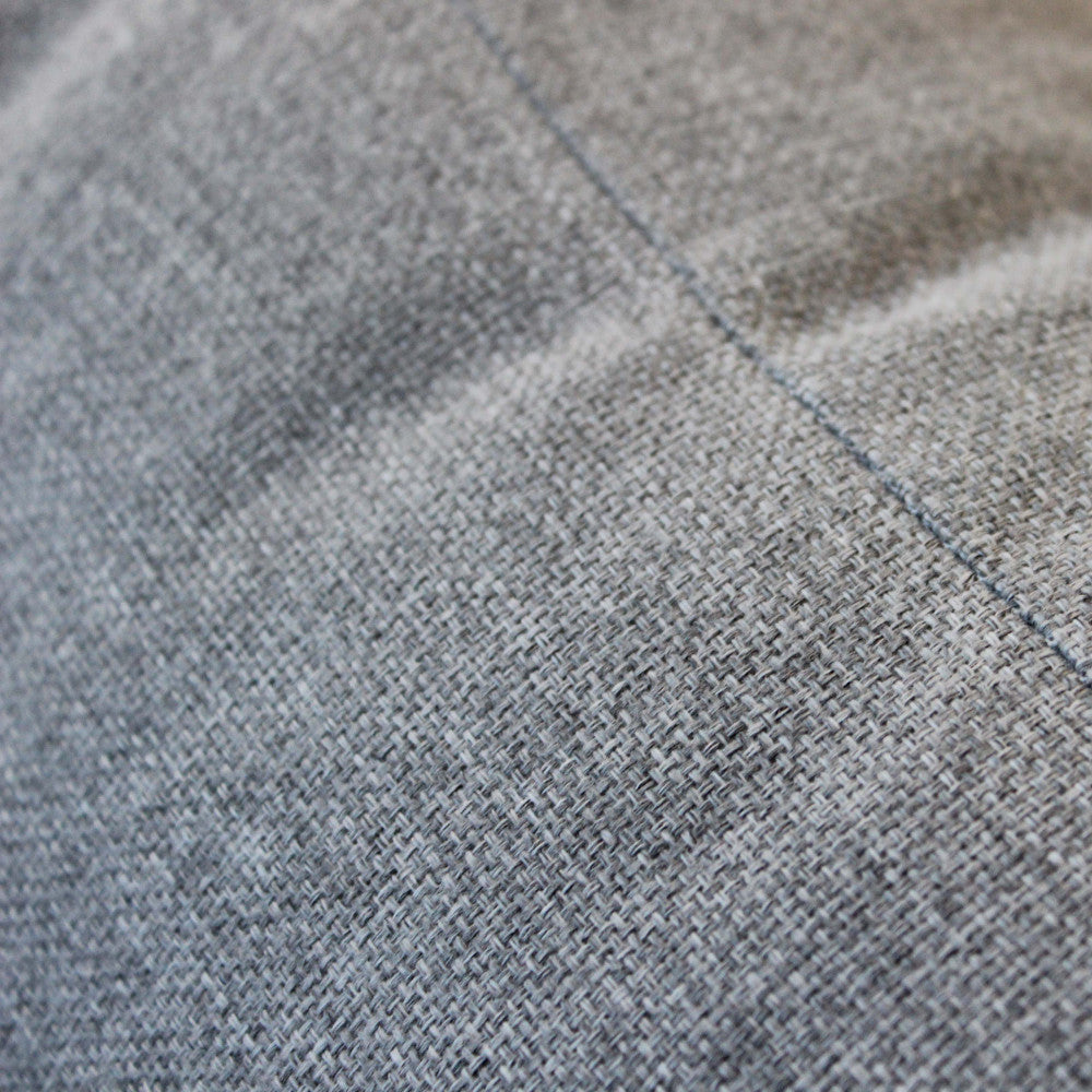 Texture ravvicinata del tessuto grigio chiaro in cotone e poliestere.