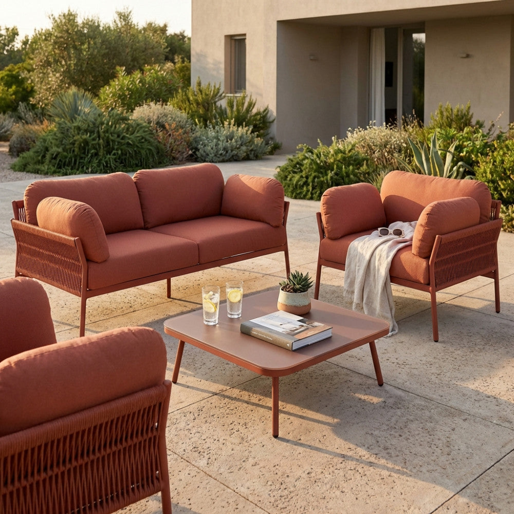 Un elegante patio con il divano, le poltrone e il tavolino Belém in tonalità rossa.