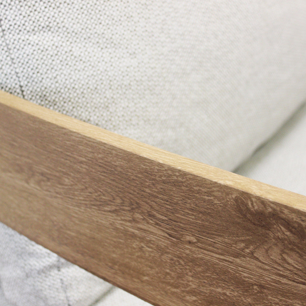 Dettaglio del bracciolo in alluminio finitura legno, che contrasta con la trama fitta e resistente del tessuto olefin grigio chiaro.