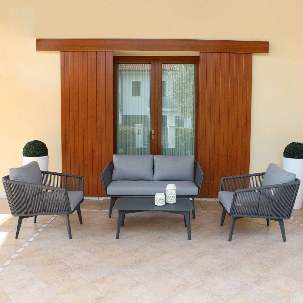 Il Salotto Cancun 2 Posti completo, ambientato in uno spazio esterno, che mostra l'eleganza e il comfort per il relax all'aria aperta