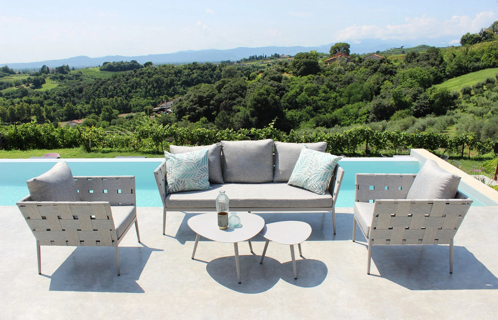 Salotto Dakar Tortora da esterno in Alluminio verniciato, composto da divano 3 posti, due poltrone e due tavolini, con cuscini inclusi. ambientazione in esterna a bordo piscina