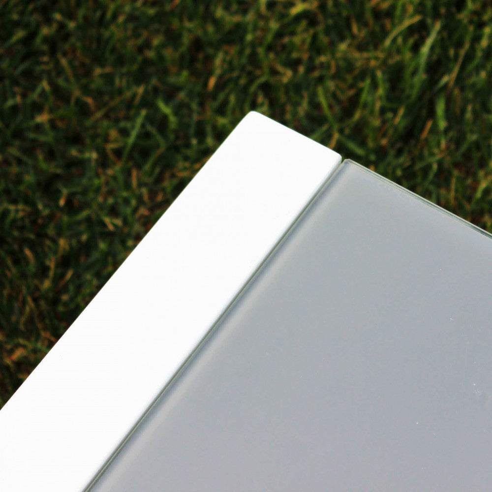 Particolare del piano in vetro temperato opaco e della struttura in alluminio bianco del tavolino.