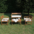 Salotto Giardino Bali completo in legno di acacia massiccio con cuscini bianchi spessi, in un ambiente esterno.