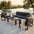 Salotto da esterno Knoxville in alluminio antracite posizionato a bordo piscina al tramonto.