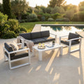 Salotto Knoxville in alluminio bianco con cuscini antracite allestito a bordo piscina al tramonto.