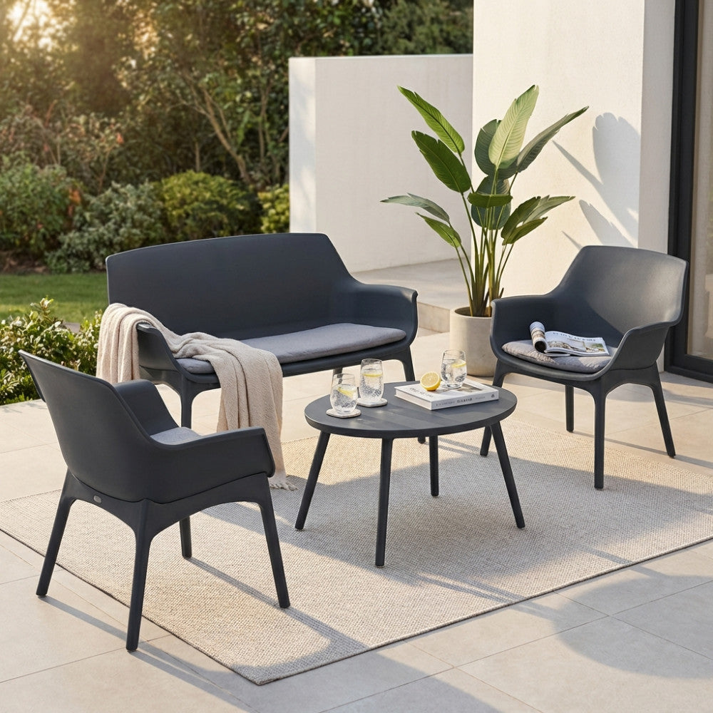 Vista angolare del salotto Luxor a quattro posti con tavolino centrale e cuscini grigi.