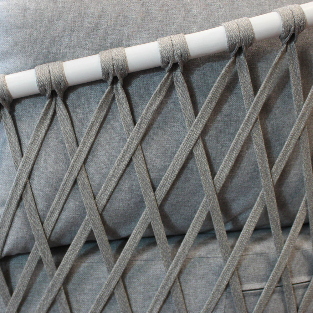 Dettaglio ravvicinato dell'intreccio geometrico in corda sulla struttura bianca del salotto Mérida.