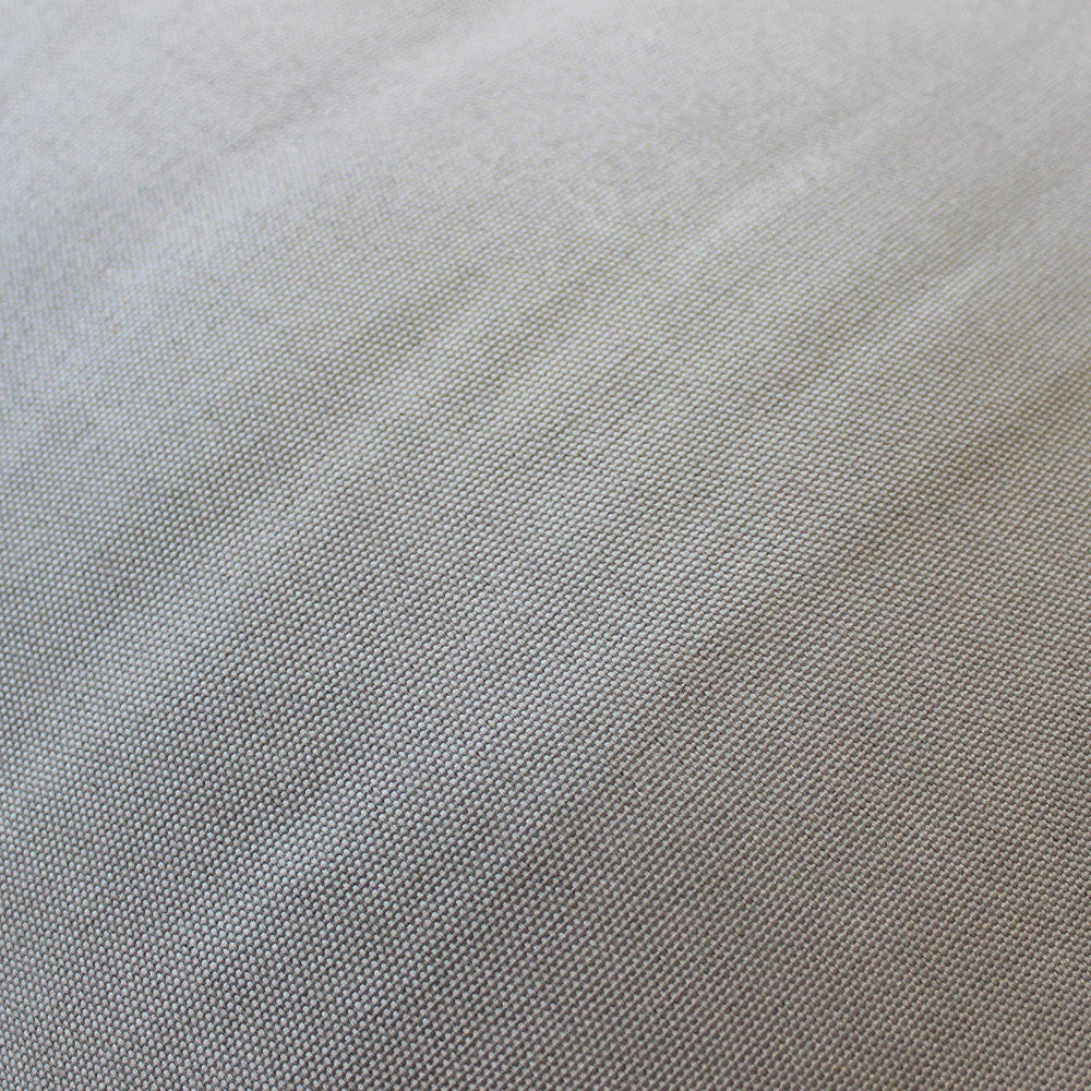Scatto macro della trama del tessuto in cotone e poliestere grigio chiaro, che rivela la tessitura fine e la composizione resistente.