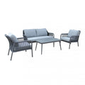 Set salotto da esterno Madeira 2P in alluminio verniciato antracite con cuscini grigi, composto da divano a due posti, due poltrone e un tavolino, ambientato in un patio con ghiaia bianca e parete in pietra.