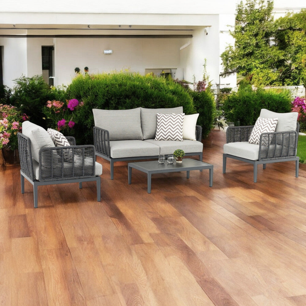 Salotto Marigot inserito in un rigoglioso giardino contemporaneo con pavimentazione in legno.