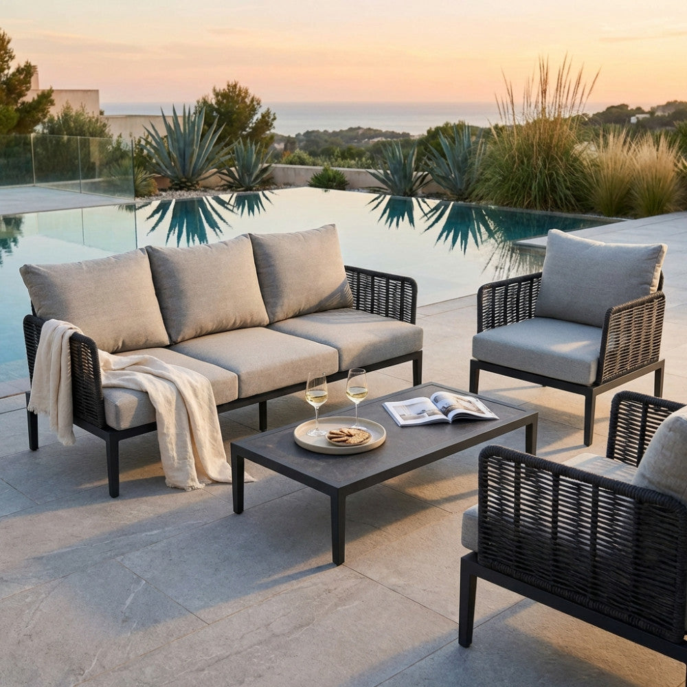 Set divano e poltrone Marigot color antracite a bordo piscina al tramonto.