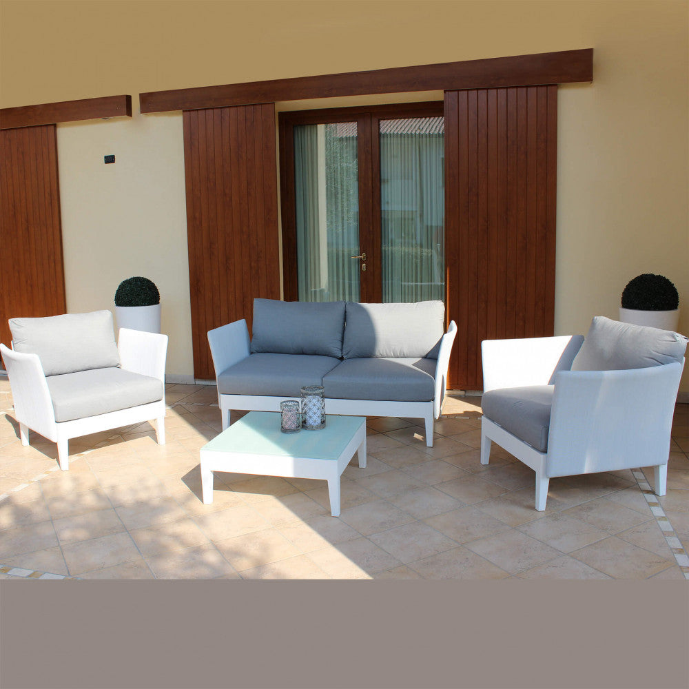 Salotto Minneapolis posizionato su una terrazza piastrellata di fronte a grandi porte finestre con persiane in legno.
