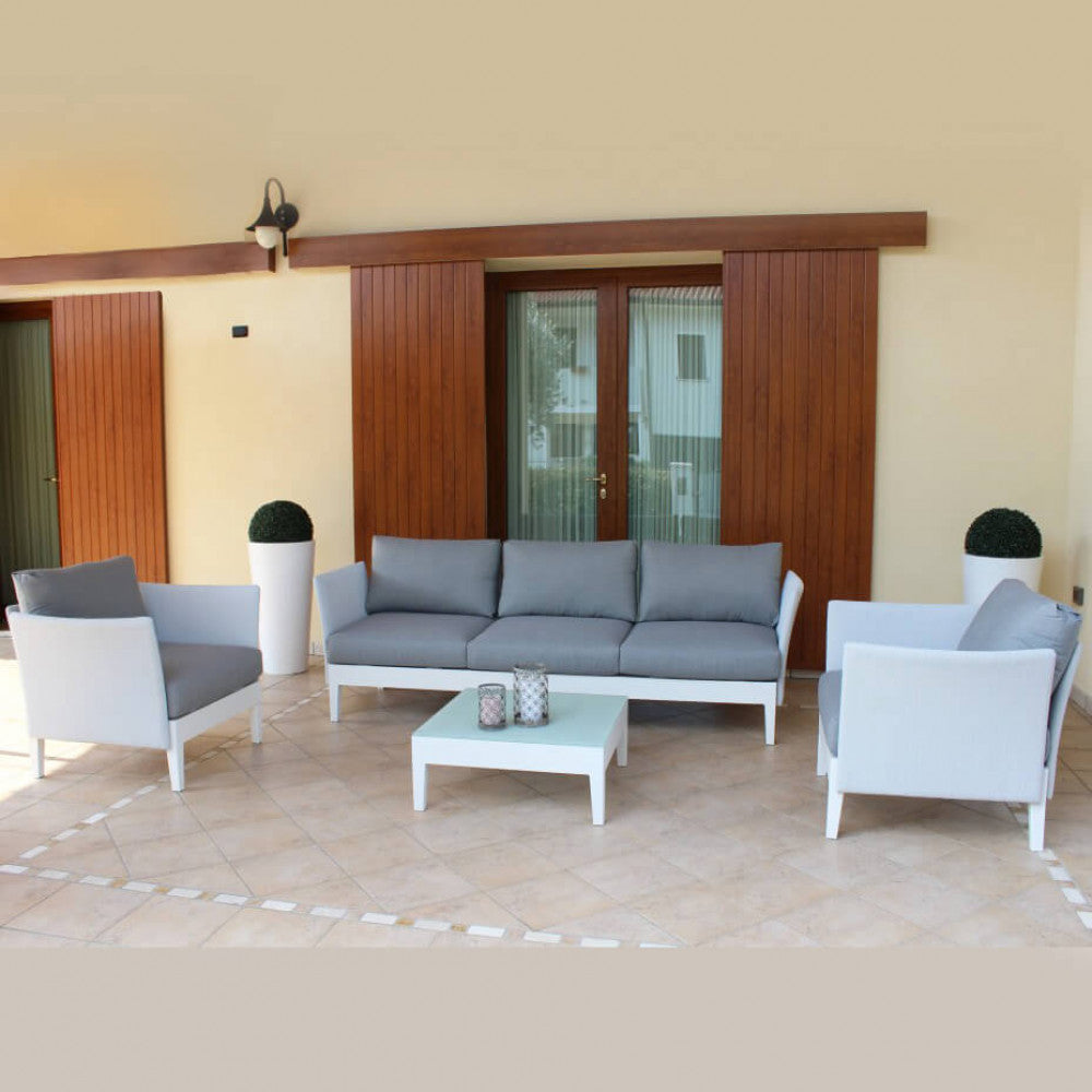 Il Salotto Minneapolis 3 Posti completo, ambientato in un giardino, che mostra l'eleganza e la funzionalità per il relax all'aperto