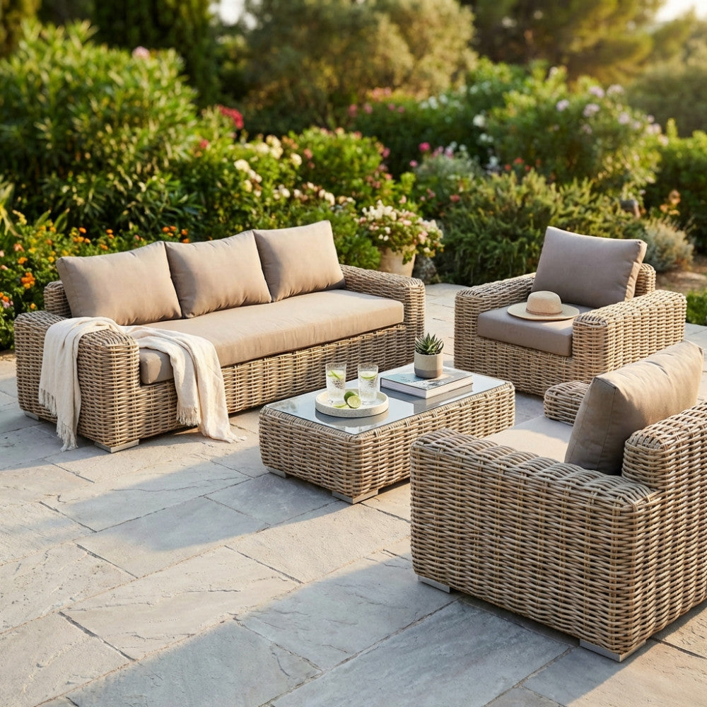 Vista d'insieme del salotto Ramirez a 5 posti in wicker marrone, allestito in un elegante giardino pavimentato in pietra al tramonto.