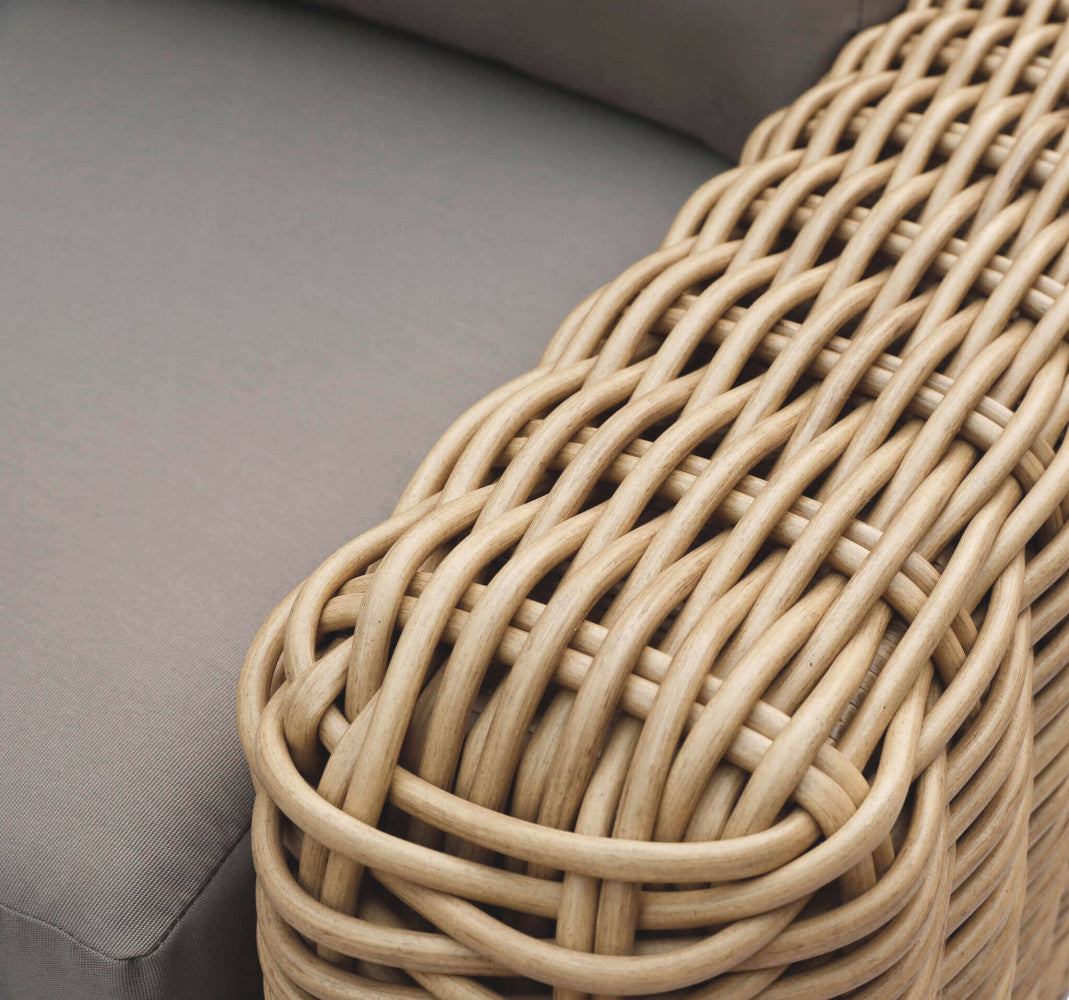 Dettaglio macro dell'intreccio in wicker marrone sul bracciolo della poltrona Ramirez, che esalta la maestria artigianale e la texture materica.