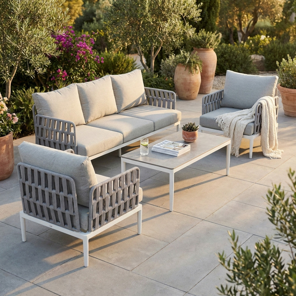 Salotto Saint John a 5 posti in corda poliestere grigio chiaro ambientato in un giardino mediterraneo.