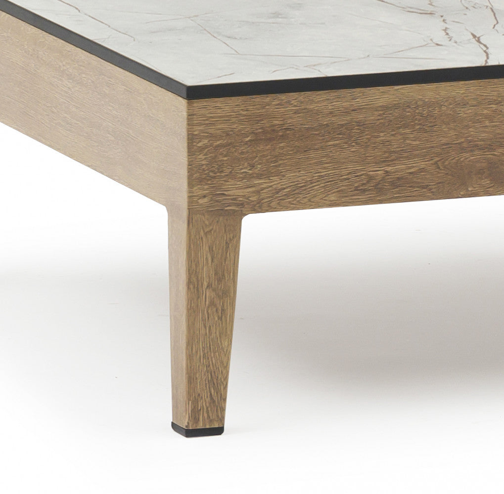 Dettaglio della gamba del tavolino Santos in alluminio finitura legno e del piano in ceramica effetto marmo.
