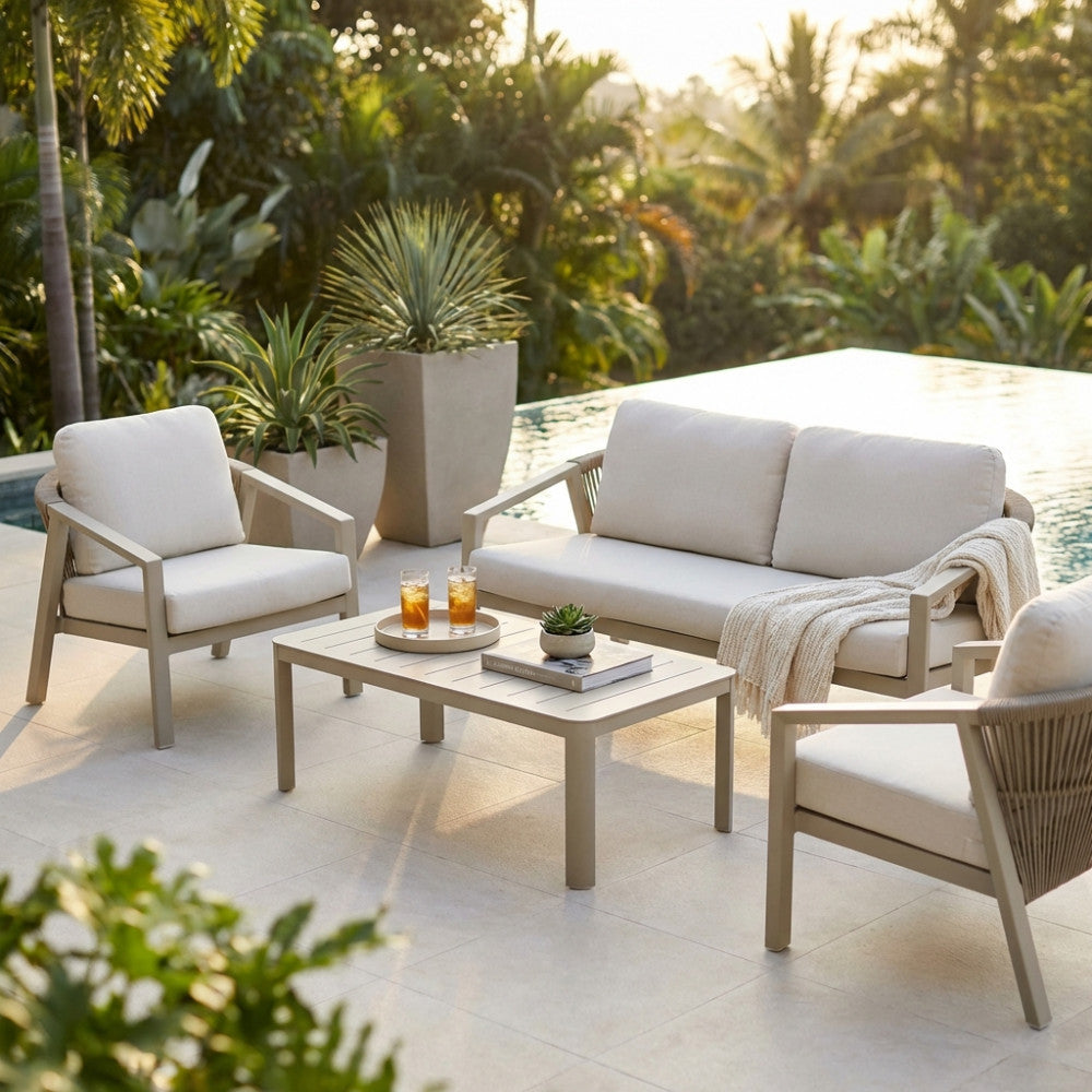 Set lounge Tijuana con divano, due poltrone e tavolino a bordo piscina circondato da vegetazione tropicale.