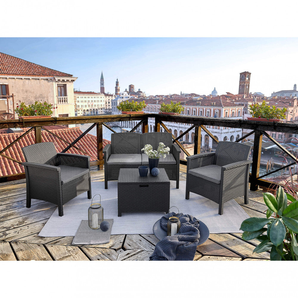 Salotto da esterno nero allestito su una terrazza in legno con vista panoramica sui canali di Venezia.