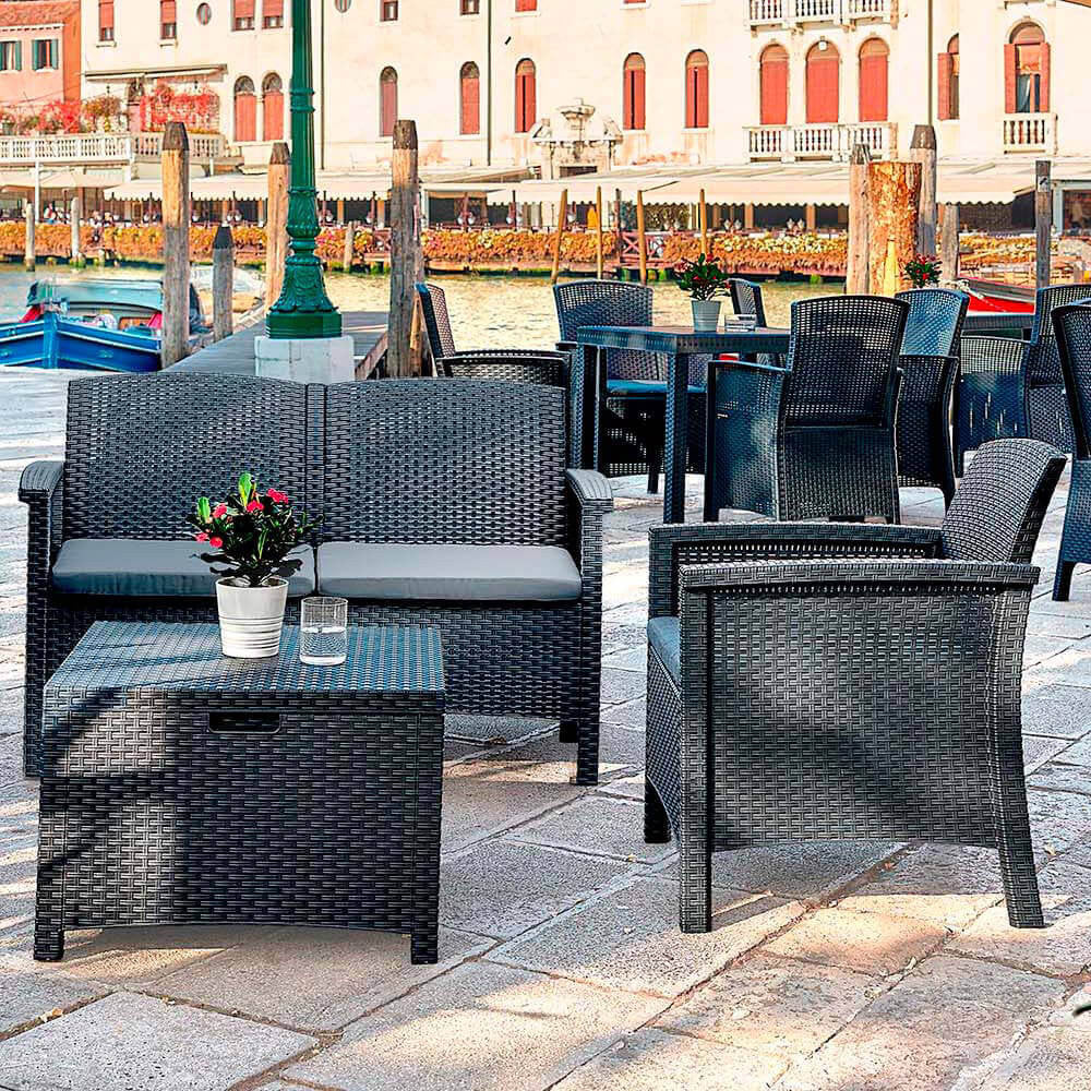 Composizione outdoor a quattro posti posizionata su una pavimentazione in pietra lungo un canale veneziano.