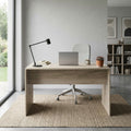 Scrivania Josie in rovere grigio posizionata in un luminoso home office con vista sul giardino, allestita con laptop e lampada da tavolo.