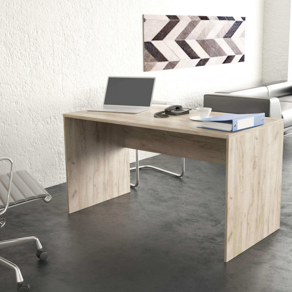 Scrivania Josie ambientata in un ufficio moderno con pavimento scuro, decorata con accessori da lavoro e un raccoglitore blu.