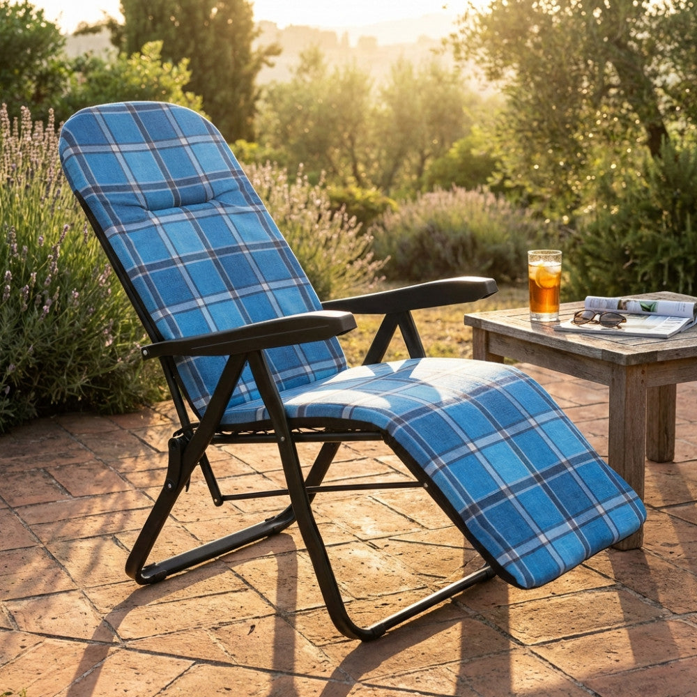 Poltrona relax Cipro con motivo scozzese blu e verde posizionata su un patio in cotto al tramonto.