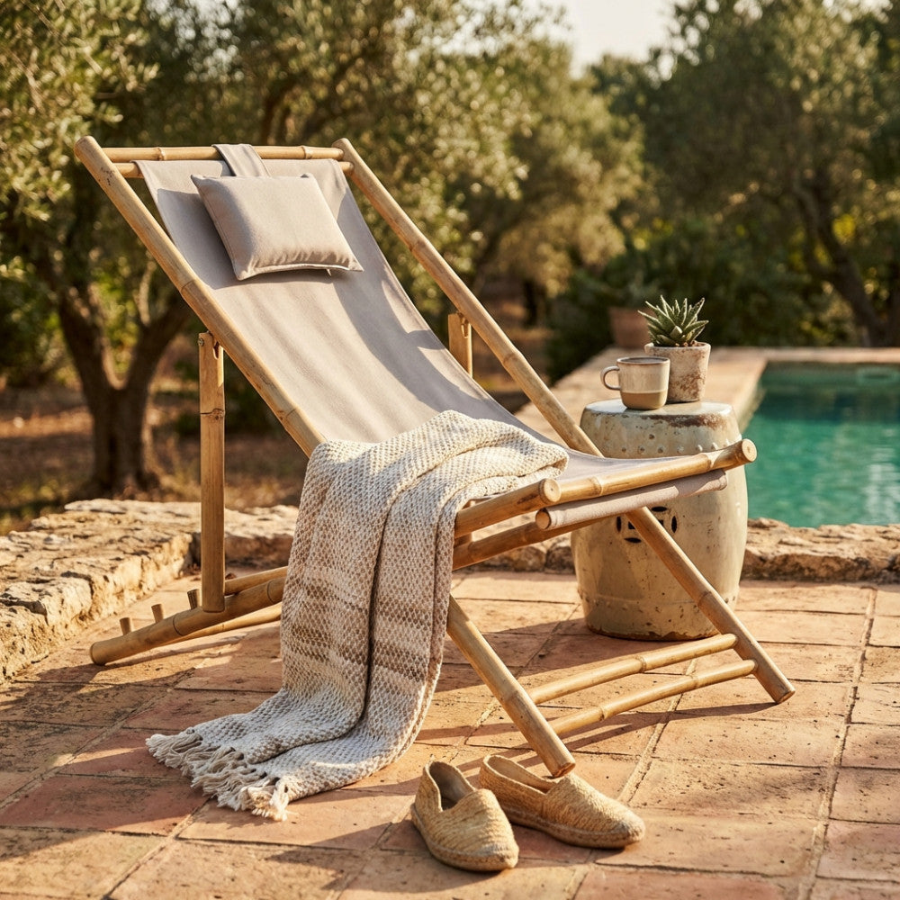Sdraio Daiquiri in legno posizionata su pavimentazione in cotto, decorata con coperta intrecciata e sgabello in ceramica.