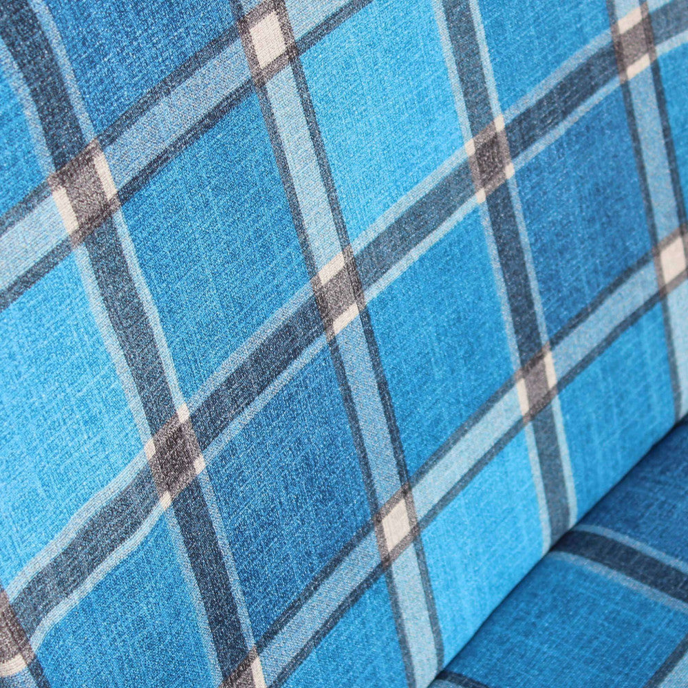 Dettaglio ravvicinato della trama tattile del tessuto scozzese nei toni del blu, azzurro e bianco.