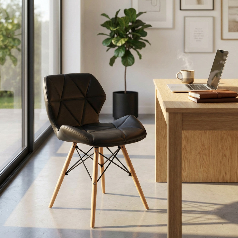 Sedia Annapolis nera in poliuretano e legno ambientata in uno studio moderno con scrivania e pianta.
