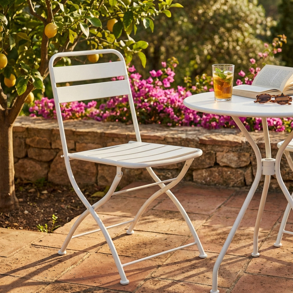 Dettaglio della sedia Bristol in acciaio bianco in un contesto outdoor con fiori e limoni.