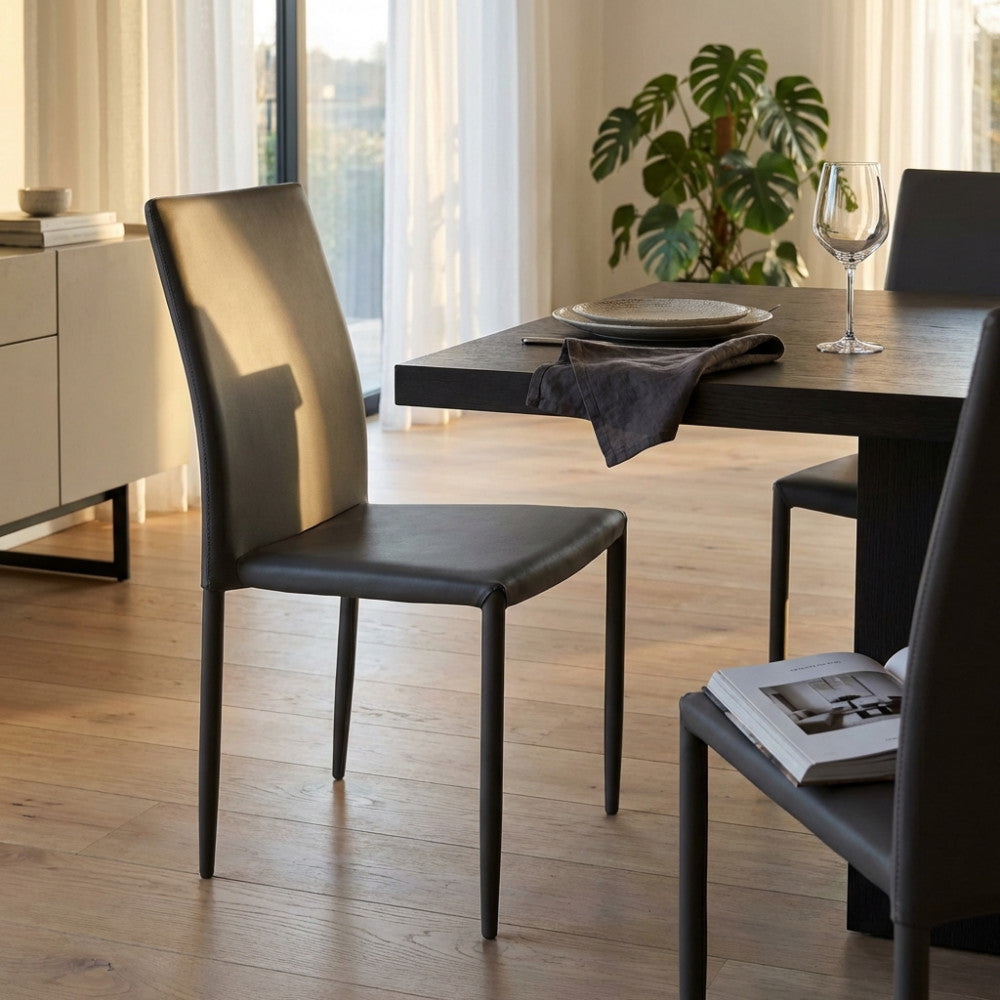 Sedia Cammie in ecopelle marrone posizionata in una luminosa sala da pranzo moderna.