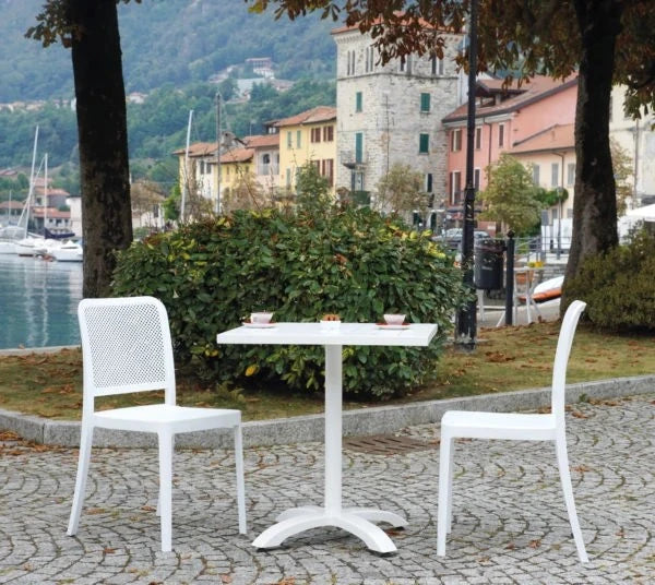 Sedia Catania Bianca impilabile senza braccioli, in Polipropilene con Fibra di Vetro, resistente ai raggi UV per esterni, ambientata in giardino