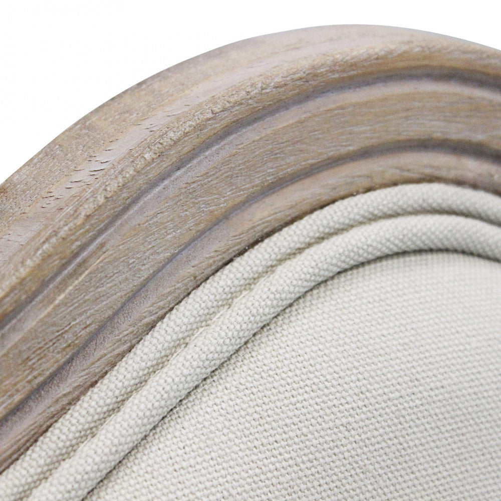 Dettaglio ravvicinato della cornice in legno e della cucitura a cordoncino sul tessuto beige dello schienale.