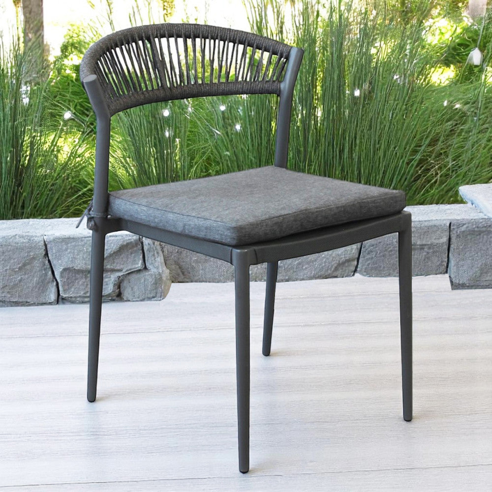 Sedia Corrientes posizionata su una pavimentazione chiara con uno sfondo di piante verdi decorative.