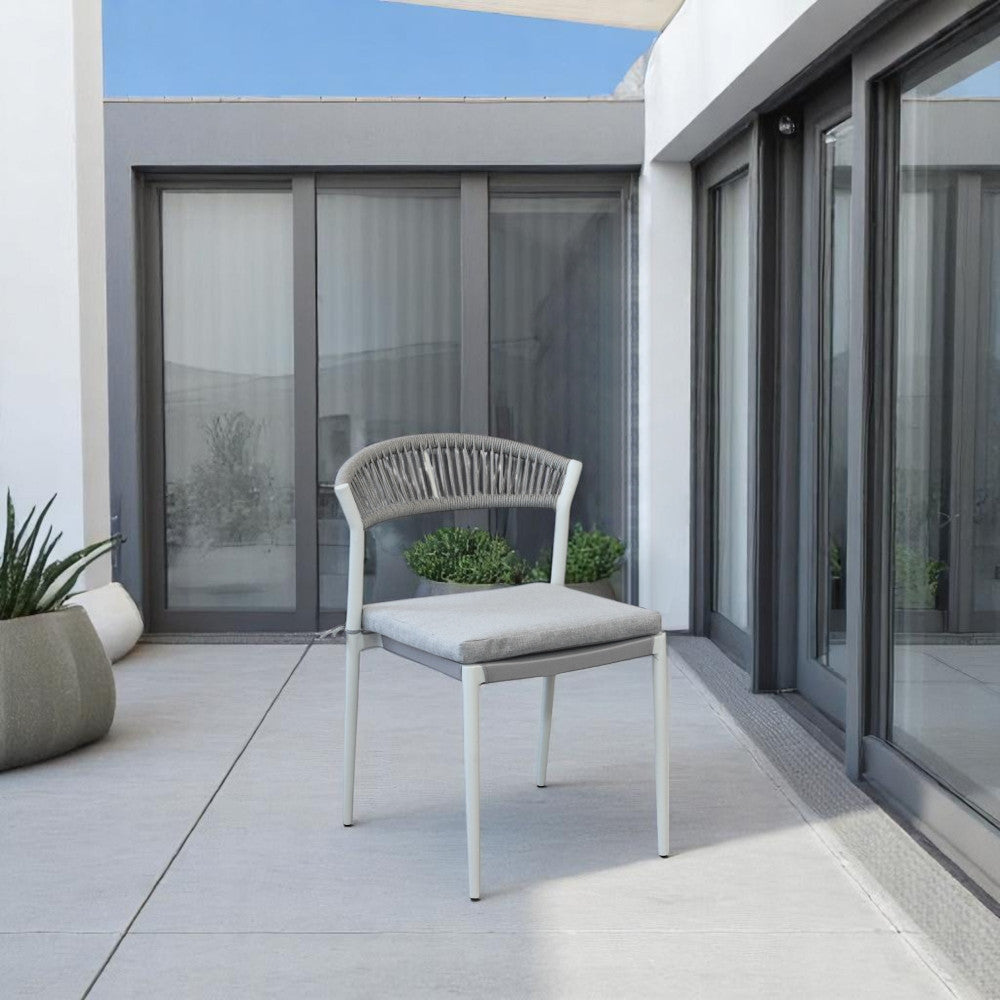 Sedia Corrientes posizionata su un patio moderno con pavimentazione grigia e ampie vetrate.