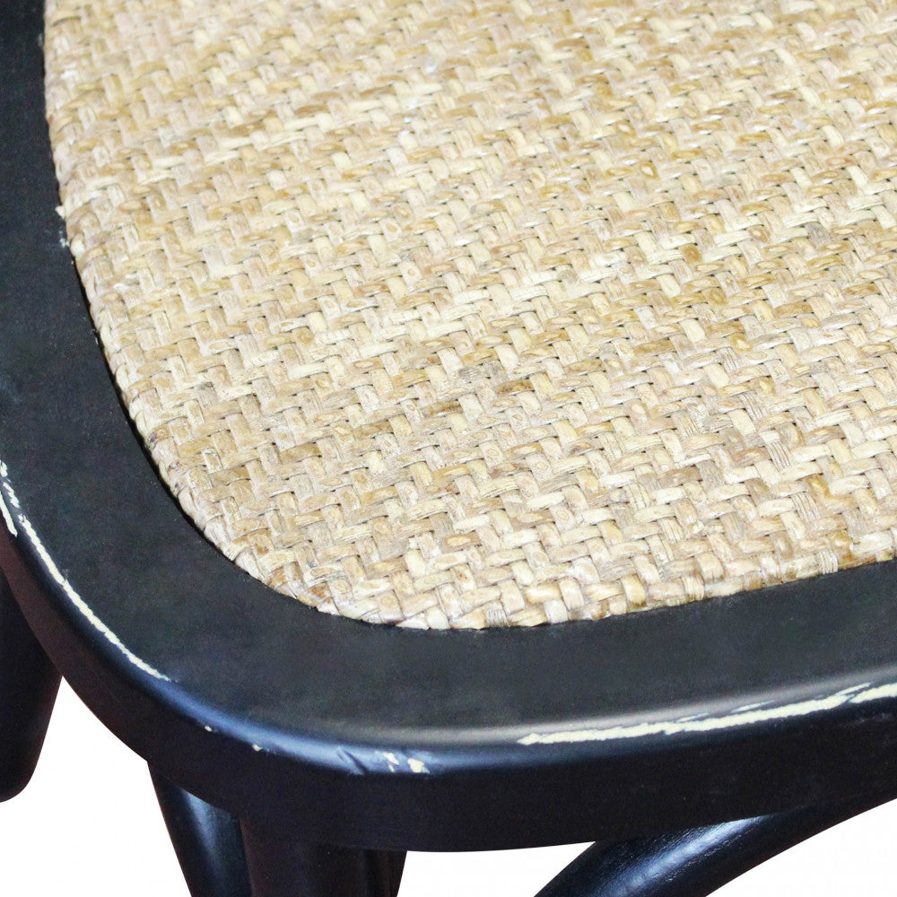 Dettaglio macro della seduta in rattan naturale intrecciato sulla struttura in legno nero.