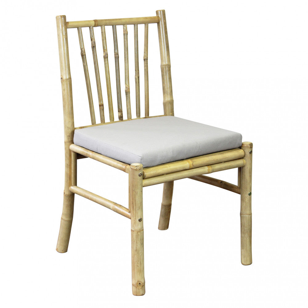 Vista angolata della sedia CUBA LIBRE in legno naturale con cuscino grigio su sfondo bianco.