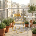 Sedia Elisabeth in acciaio giallo posizionata su un balcone moderno con piante.