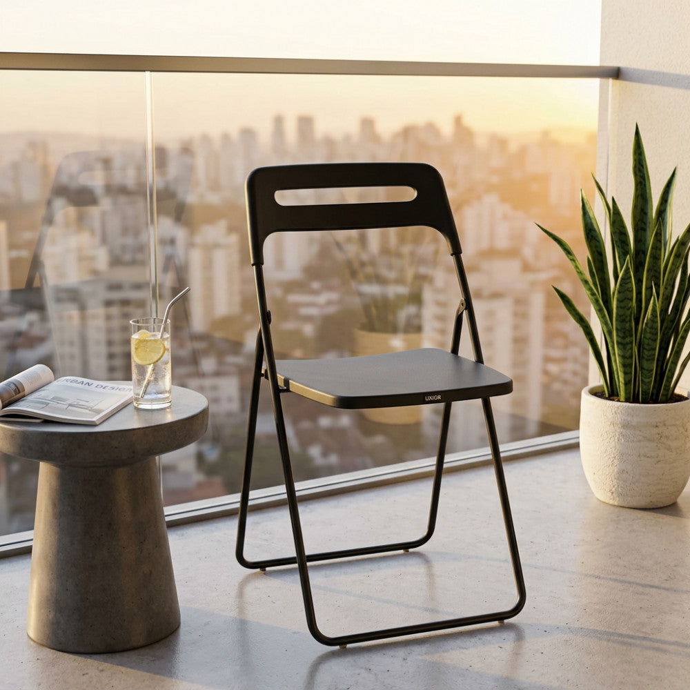 Sedia Elisabeth in acciaio antracite ambientata su un balcone moderno al tramonto con vista città.