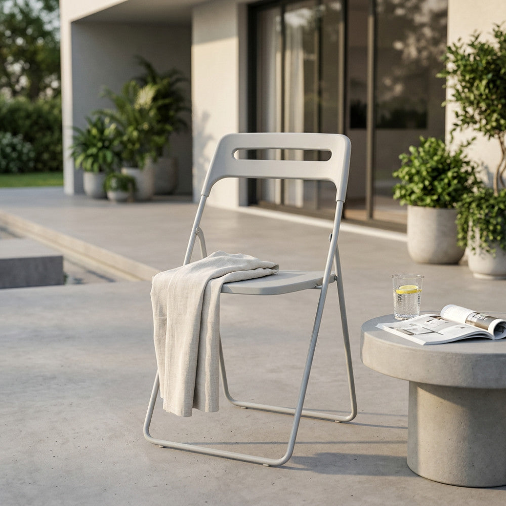 Sedia moderna Elisabeth grigio chiaro con un telo appoggiato, in un ambiente esterno elegante.