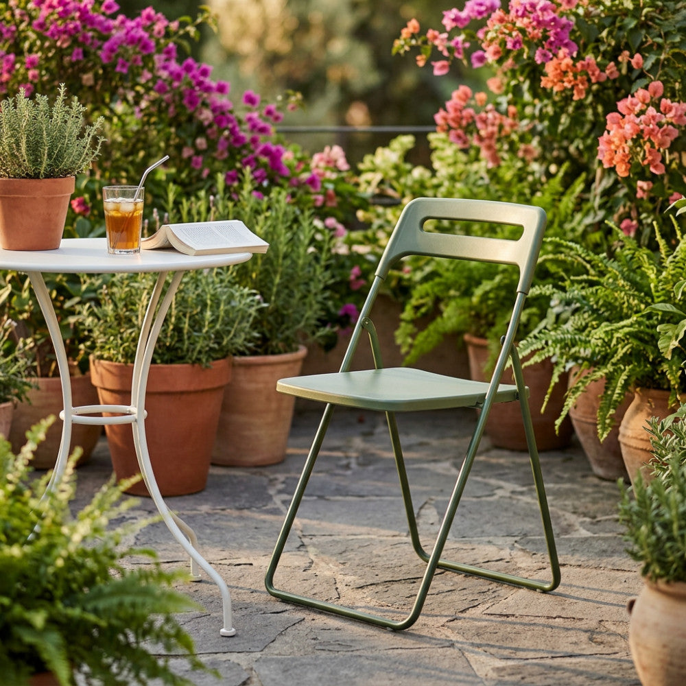 Sedia Elisabeth verde inserita in un rigoglioso giardino terrazzato con vasi in terracotta.