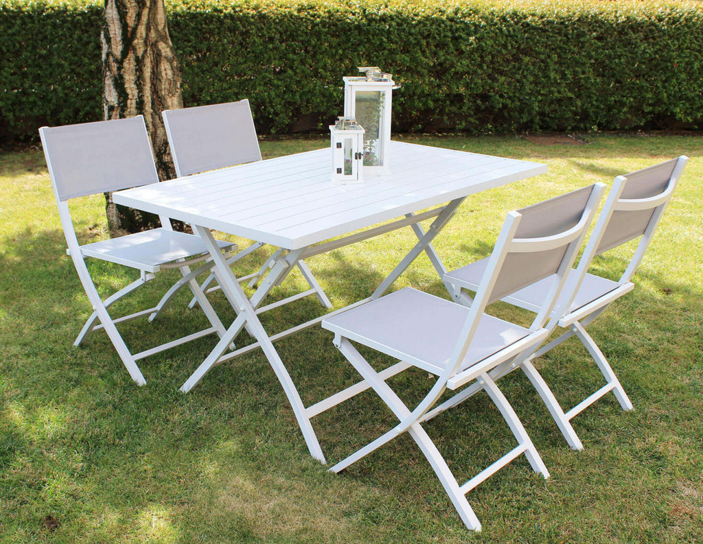Set da pranzo outdoor con quattro sedie Georgia e tavolo bianco su un prato verde curato.
