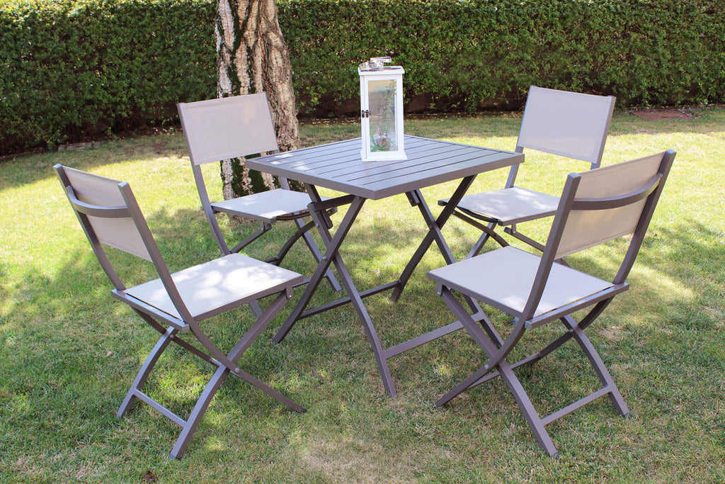 Set da giardino con quattro sedie pieghevoli Georgia e un tavolo quadrato in alluminio taupe, disposti su un prato verde.