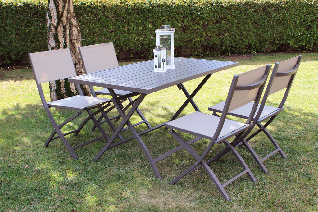 Composizione outdoor con tavolo rettangolare e quattro sedie Georgia color taupe su un prato curato.