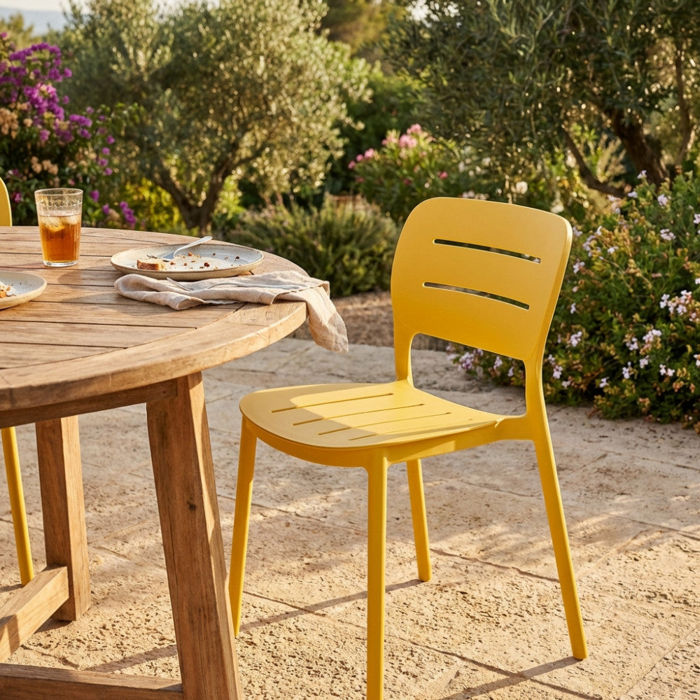 Dettaglio della sedia GISELLE moderna in un patio soleggiato con vegetazione mediterranea.