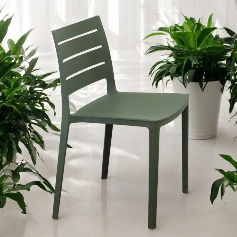 Sedia Hallie verde inserita in un contesto luminoso tra piante da interno.