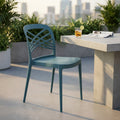 Sedia Harmonie verde petrolio ambientata su un terrazzo moderno con tavolo in cemento.