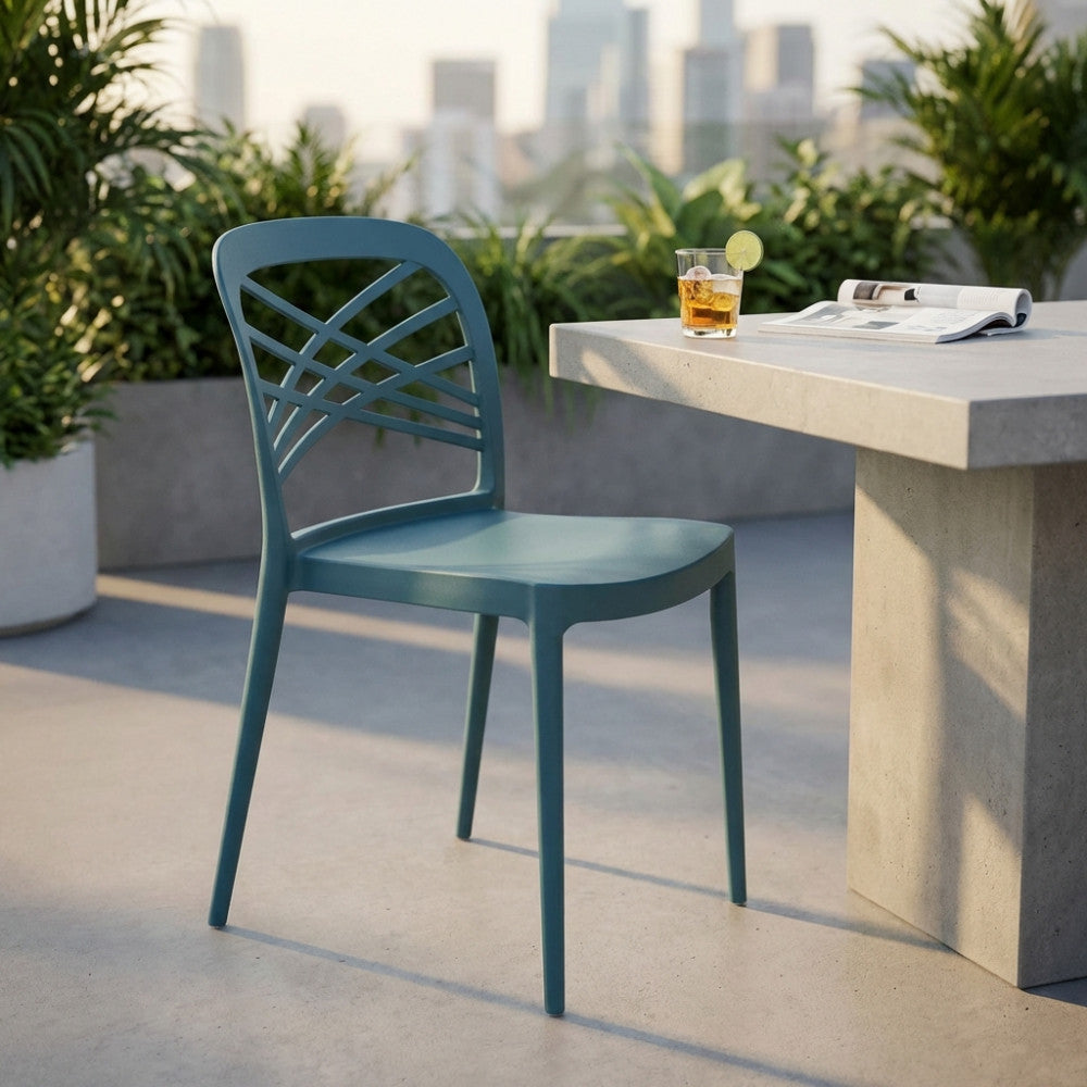 Sedia Harmonie verde petrolio ambientata su un terrazzo moderno con tavolo in cemento.